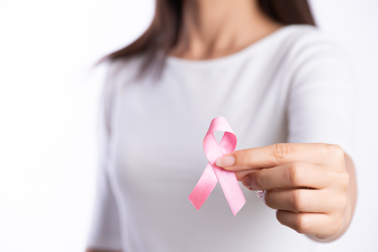אשה מחזיקה סרט ורוד המסמל את המודעות למלחמה בסרטן השד