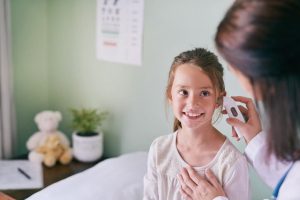 רופאה בודקת אוזניים לילדה