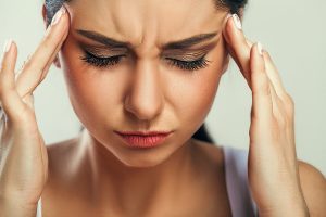 אישה עם תסמינים של כאבי ראש