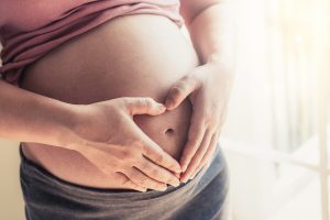 אישה בהיריון מחזיקה את הבטן לאחר בדיקת סיסי שליה