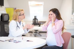 אישה בהיריון עם מיגרנה מגיעה לטיפול אצל הרופאה