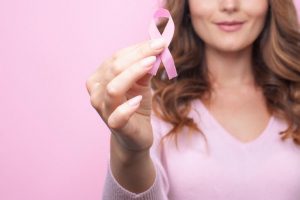 אישה מחזיקה סרט ורוד להזדהות עם סרטן השד