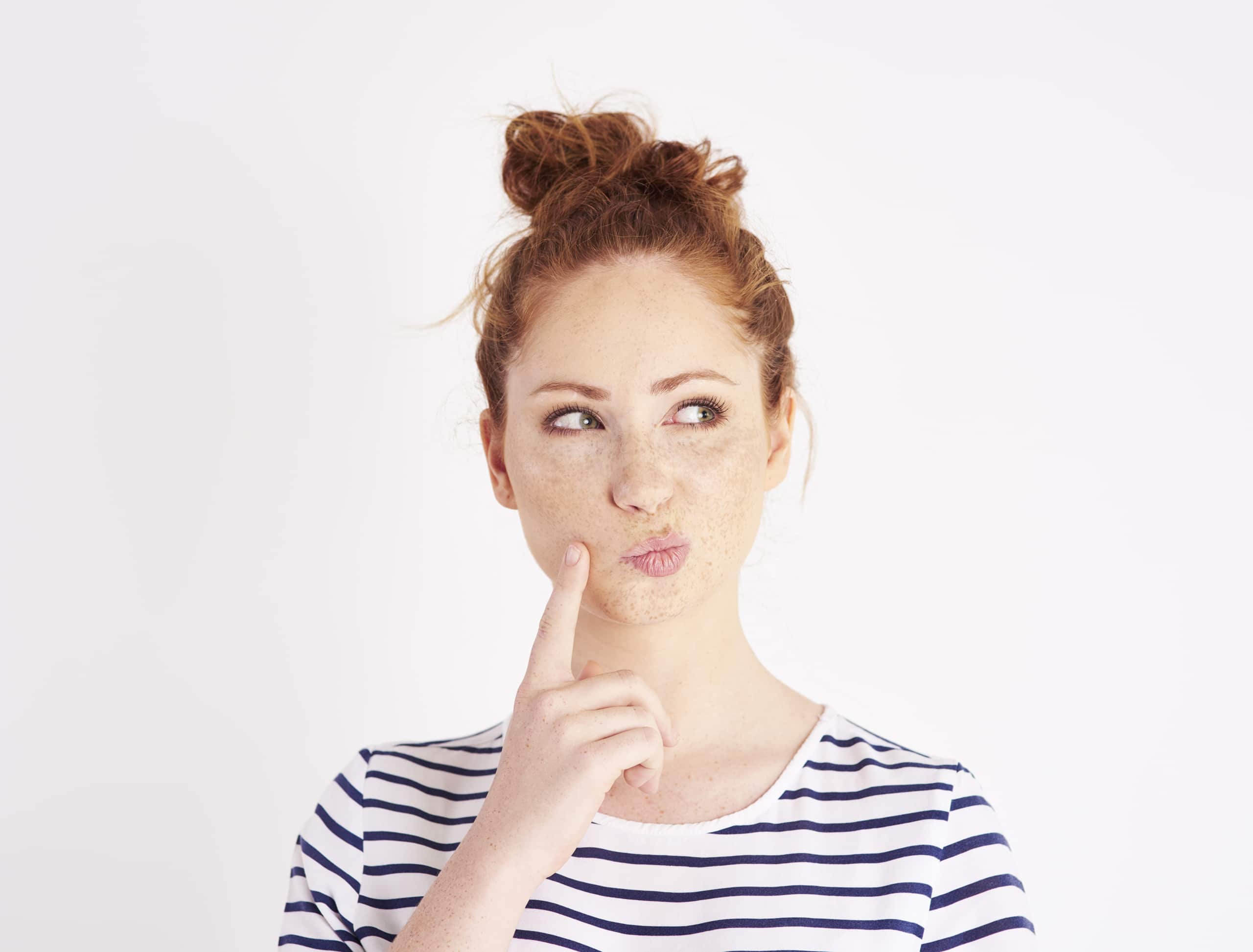 Woman With Hand On Chin Thinking At Studio Shot