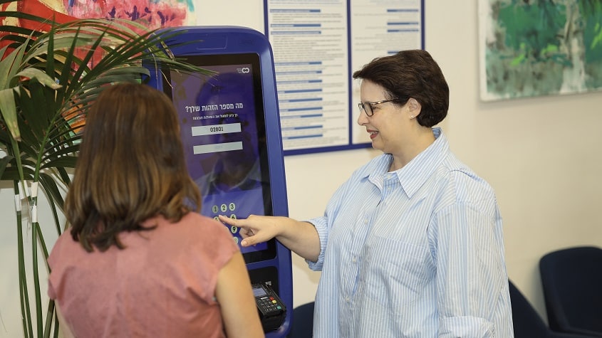 אשה מצוות אדמיניסטרציה עוזרת למישהי להתקבל לתהליך בבית החולים